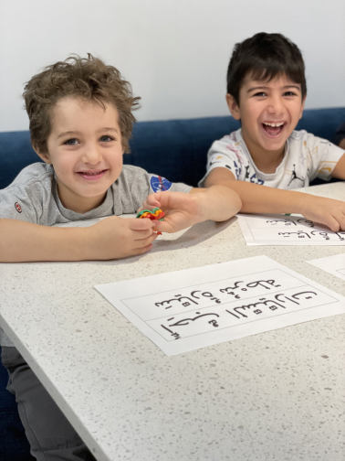 Children learning Arabic at a table